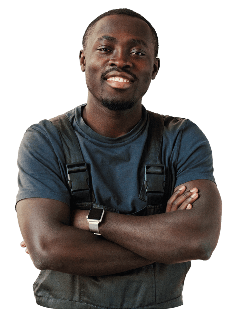 Man smiling, arms crossed, wearing overalls.